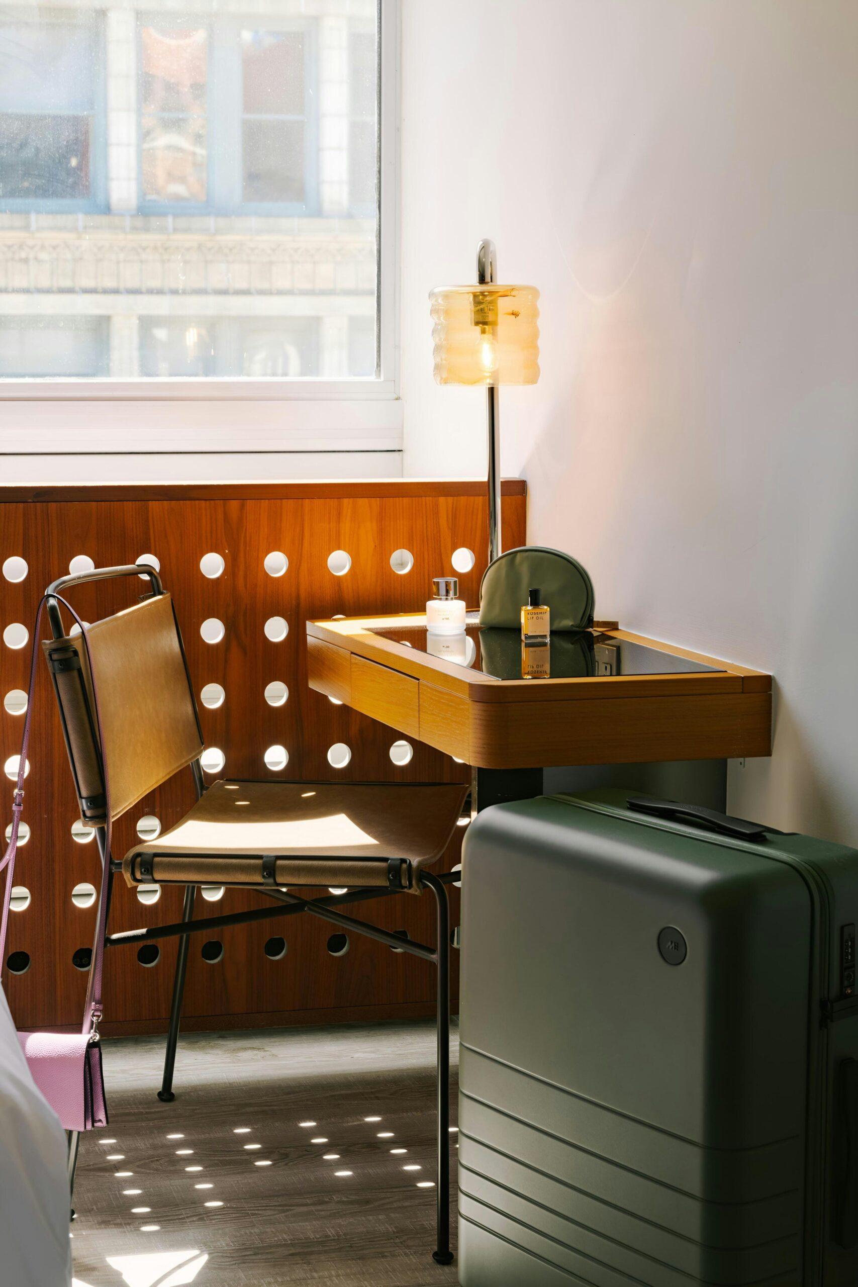 Hotel room workspace with desk, chair, luggage, and window view near places to stay near Flatiron Building NYC
