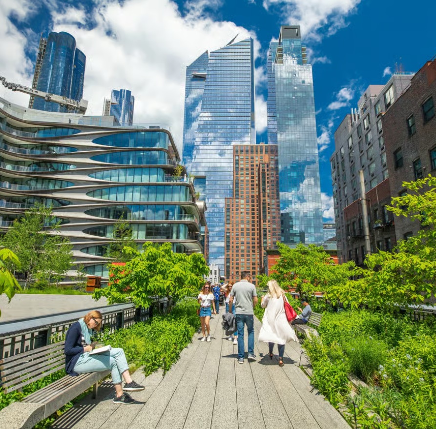 Chelsea High Line NYC walkway with greenery, people strolling, and modern skyline buildings